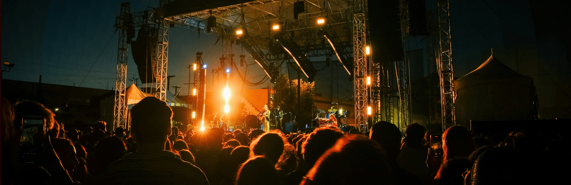 Crowd of people attending a live music concert in an outdoor stadium