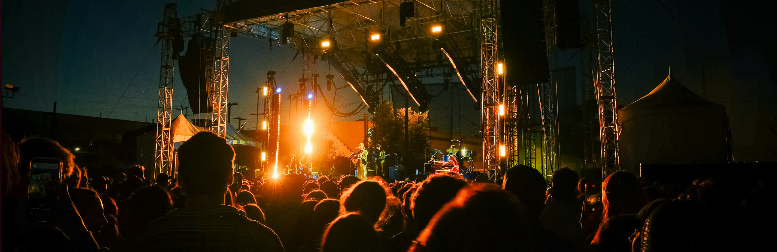 Crowd of people attending a live music concert in an outdoor stadium
